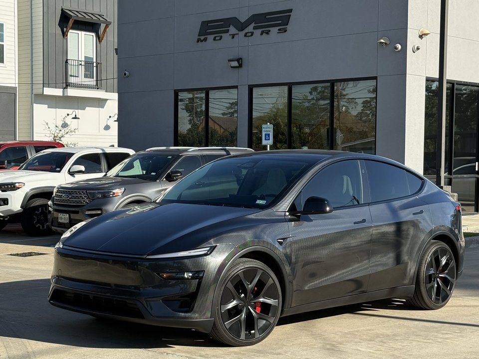 Tesla Model Y parked in front of the EVS Motors showroom at 4105 Sherwood Ln