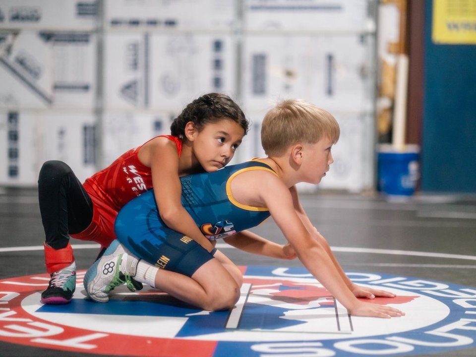 Youth wrestlers battling on a Texas USA Wrestling mat