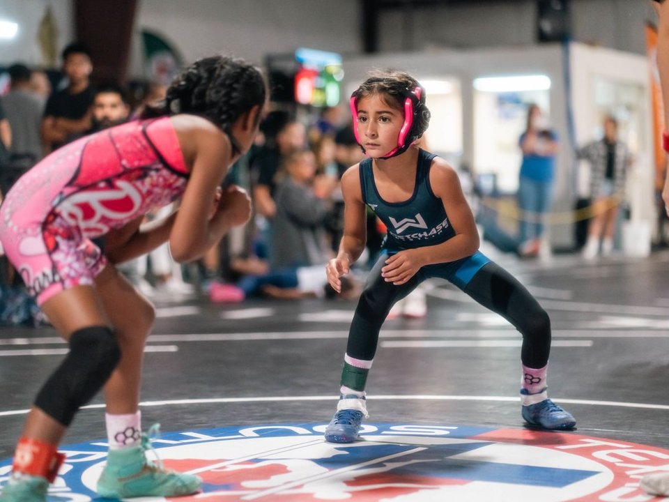 Young girls competing in a high-intensity Texas youth wrestling match