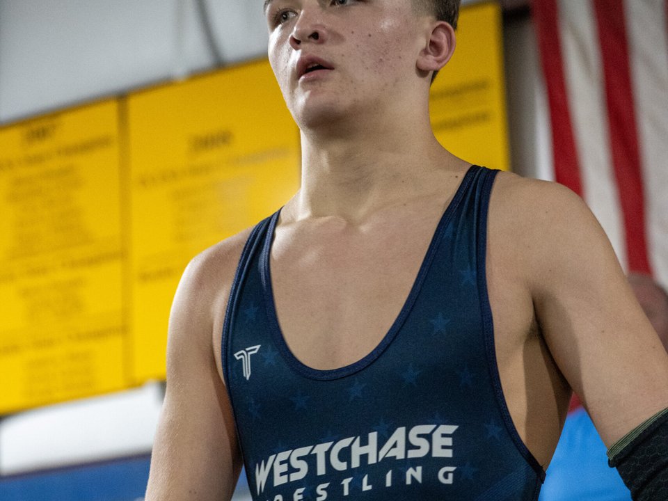 Westchase Wrestling youth athlete in navy singlet at a tournament