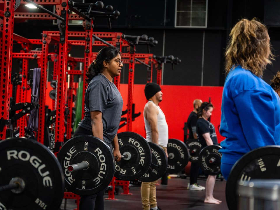 Youth and teen athletes training together at the squat racks inside Kinitro Fitness Houston